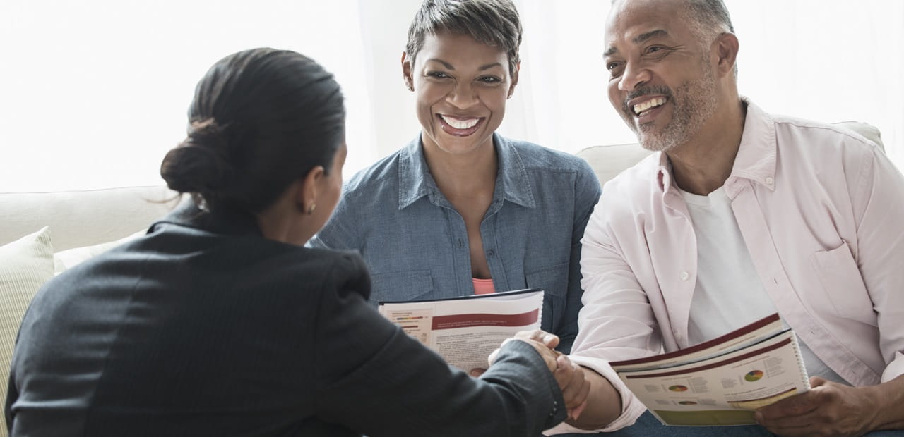 Mature Black couple talking to businesswoman