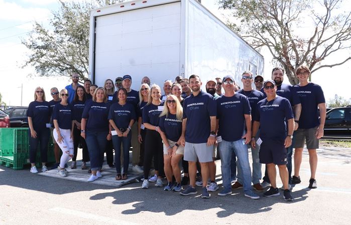 More than 30 Raymond James associates pose in Raymond James Cares shirts
