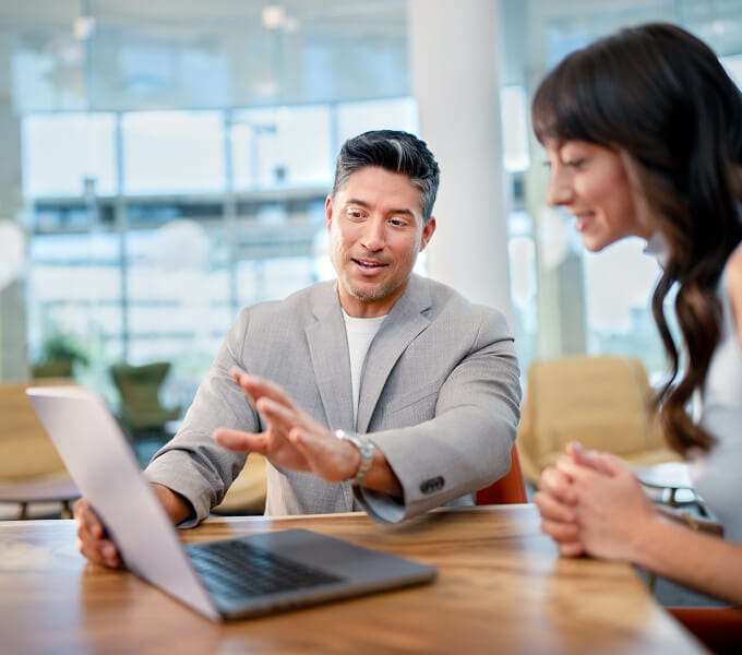 Advisor showing a client information on a laptop
